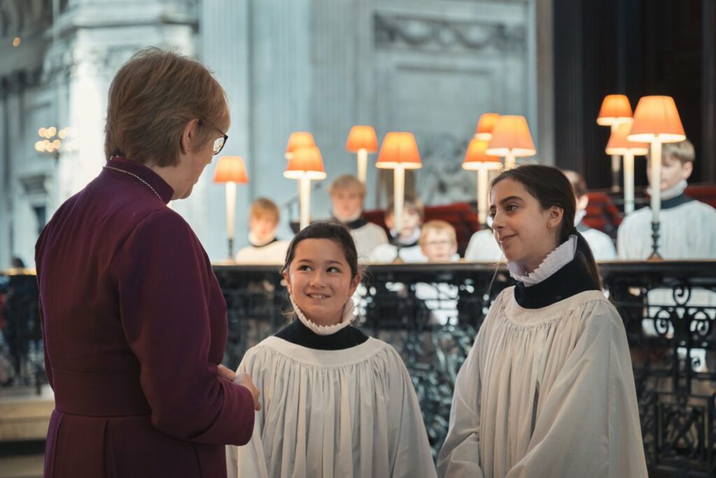 Two choristers chatting with a Bishop